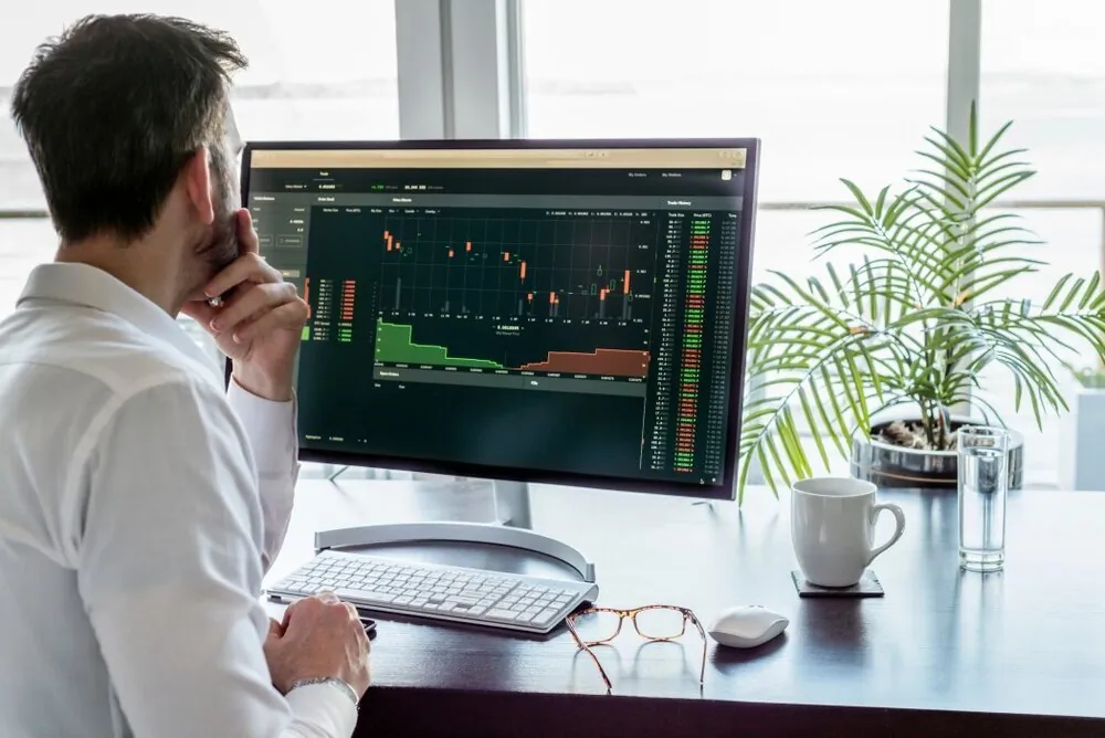 rear-view-of-man-at-desk-with-studying-computer-screen-showing-market-data-eyeglasses-keyboard-mouse_t20_4eyvzl.jpg